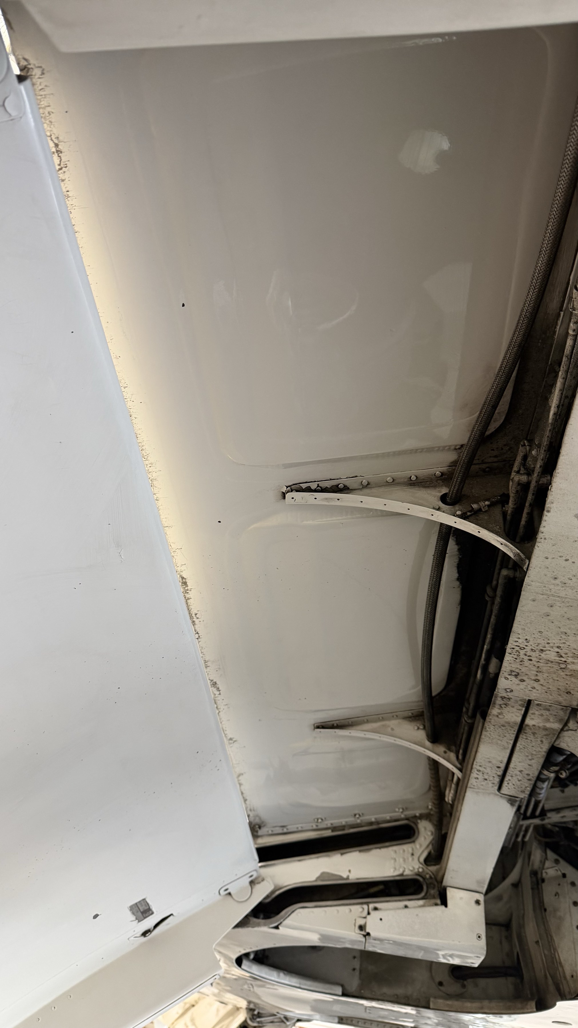The same aircraft underbelly cleaned to bright, glossy white after detailing